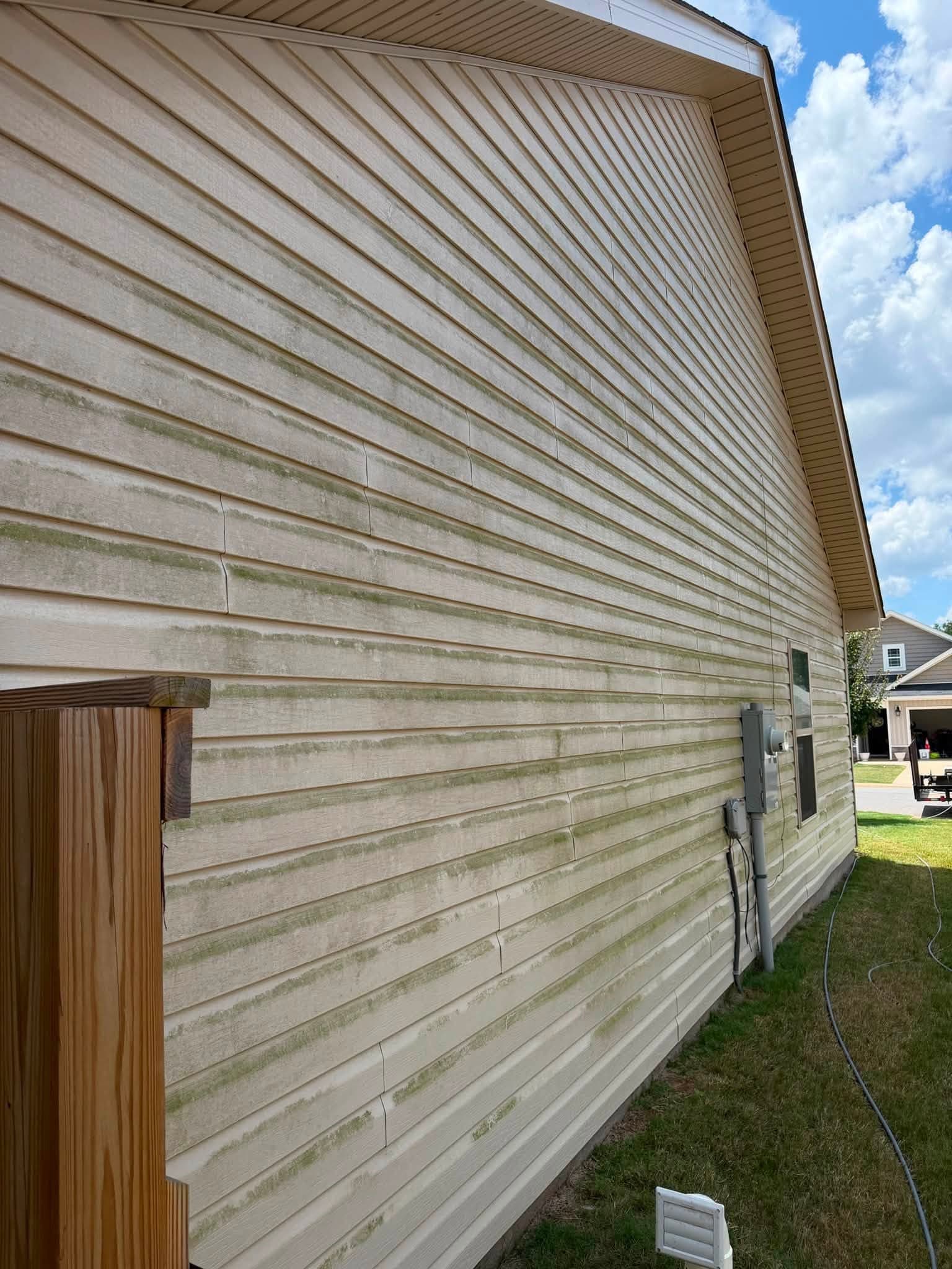 Close-up of pressure washing siding