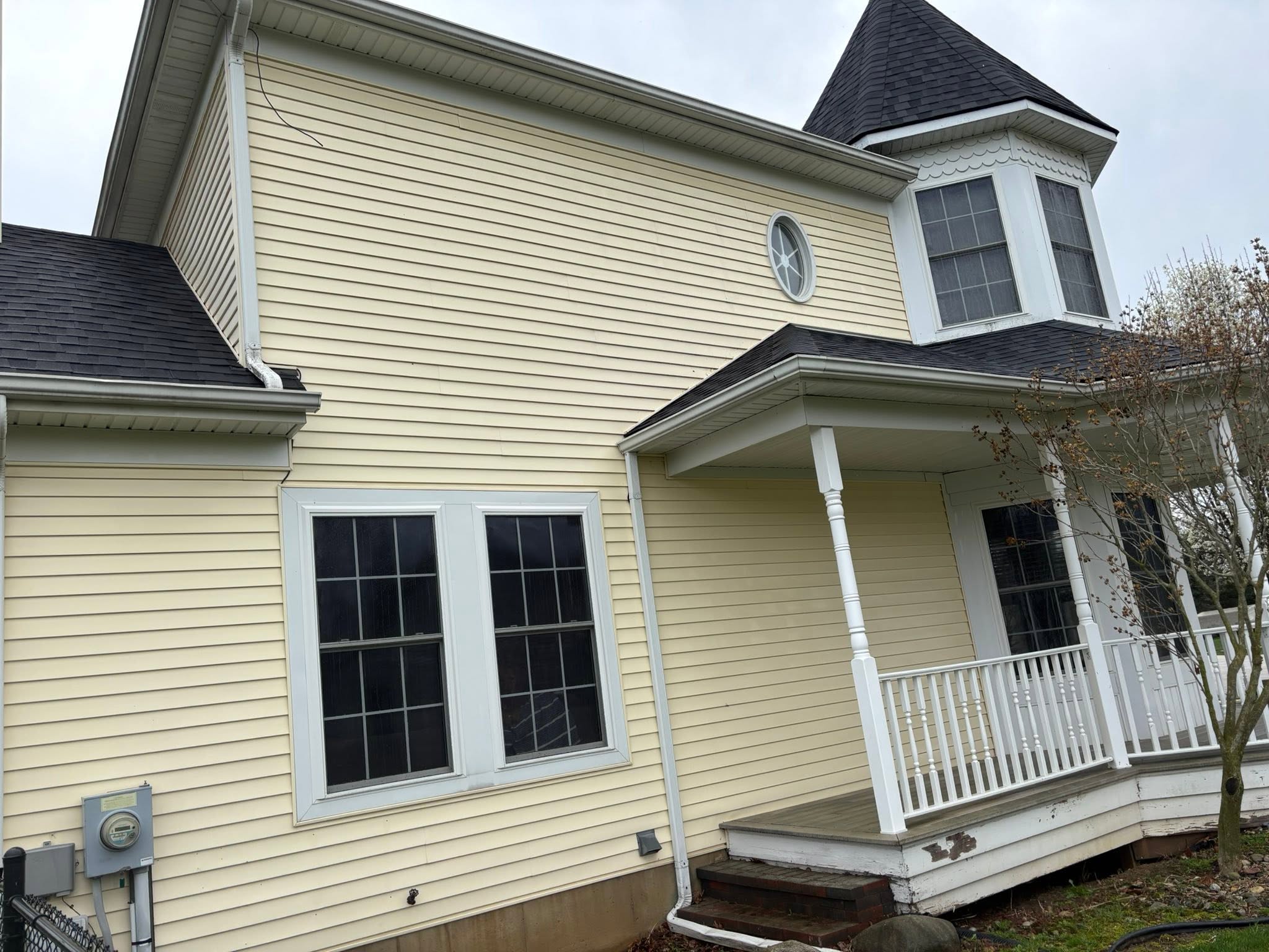 Siding restoration — pressure washing siding from a ladder